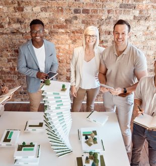 Group of diverse architects discussing plans, blueprints and schematics during a meeting in their o.