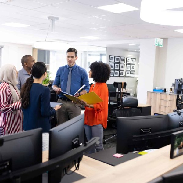 Happy diverse female and male businesspeople talking and working in office. Business, corporation, cooperation and working in office concept.
