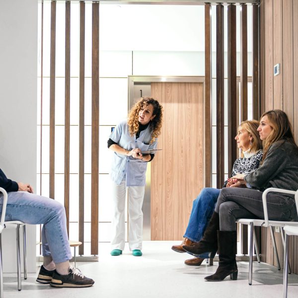 Nurse reviews patient list in waiting room before calling next appointment.